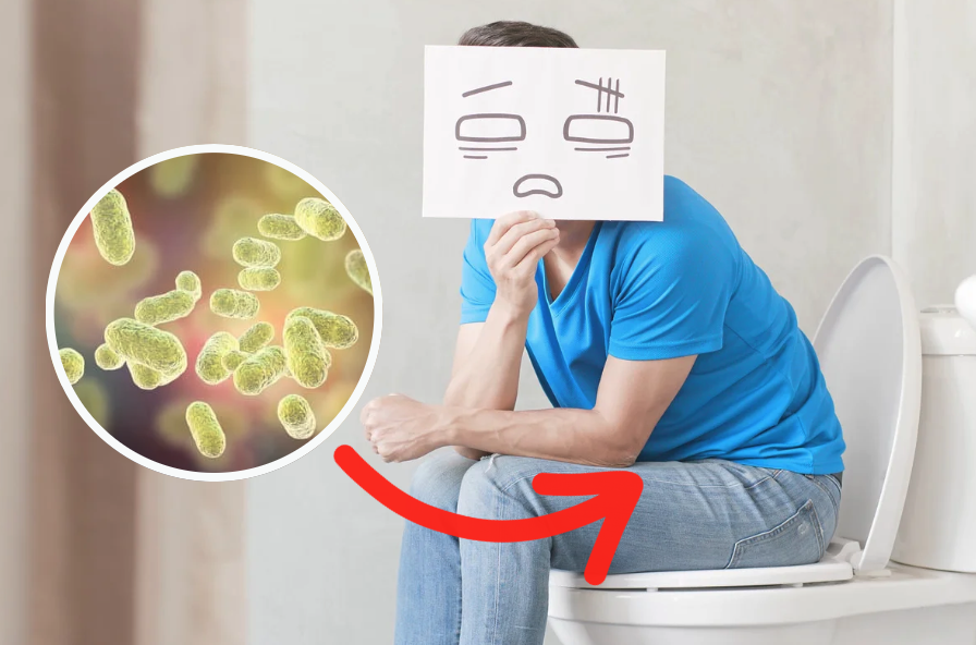 Man sitting on a toilet appearing uncomfortable, holding a paper with a distressed facial expression drawn on it, with an inset circular illustration of gut bacteria and a red arrow pointing toward his abdomen to suggest digestive discomfort or imbalance.